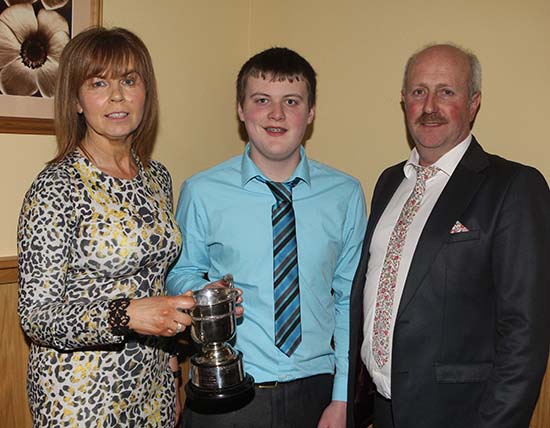 Under 21 stockjudging winner Craig Cowan, Fivemiletown, receives the Carnkern Cup from club chairman Nigel Glasgow, and his wife Phyllis. 